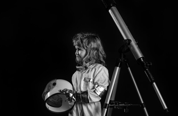 Foto niño jugando a ser un astronauta con casco espacial traje de metal y telescopio éxito creativo y comenzar