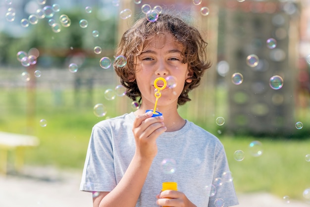 Foto niño jugando con soplador de burbujas