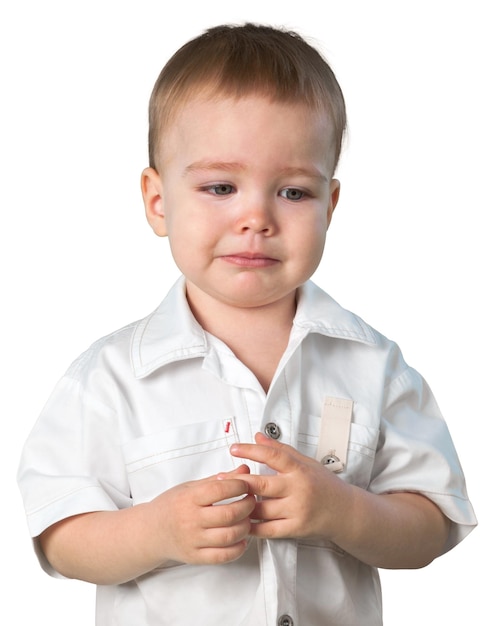 Niño jugando con su dedo y luciendo triste