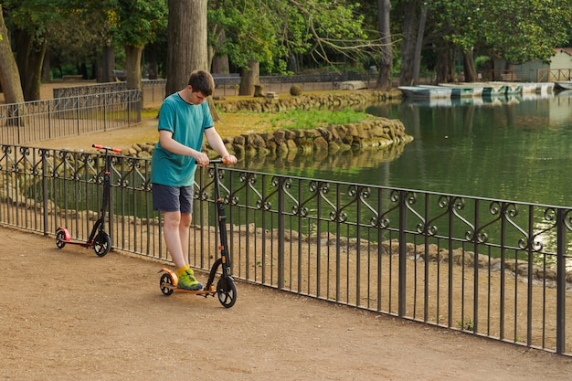 Niño jugando con su scooter en el parque