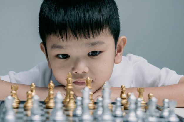 niño jugando tablero de ajedrez, competencia en los negocios,