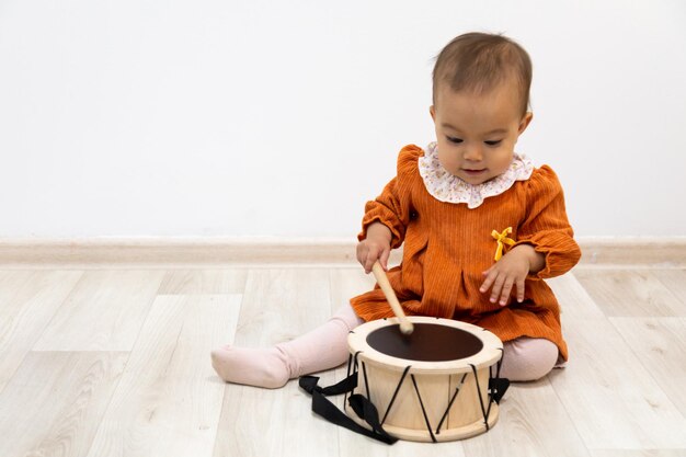 Foto niño jugando tambor de juguete