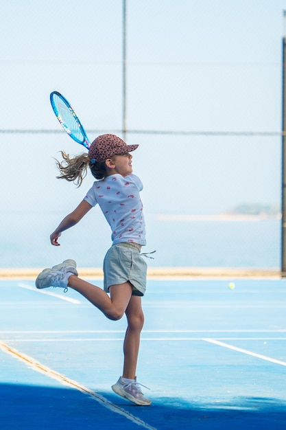 Foto niño jugando tenis en la cancha al aire libre