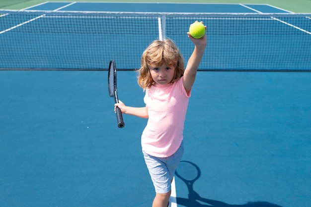 Niño jugando tenis Deporte niños Niño con raqueta de tenis en la cancha de tenis Entrenamiento para niños pequeños niños sanos