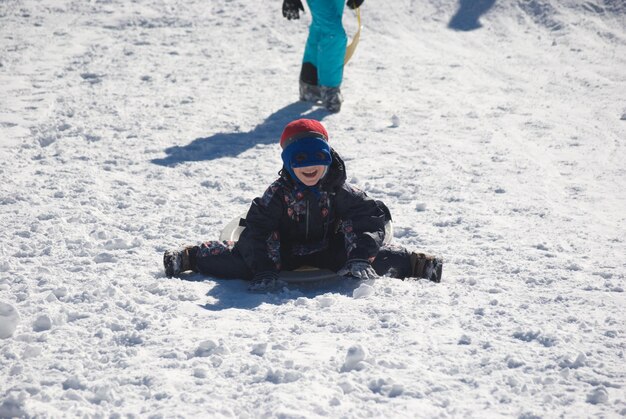 Foto niño jugando en tierra cubierta de nieve