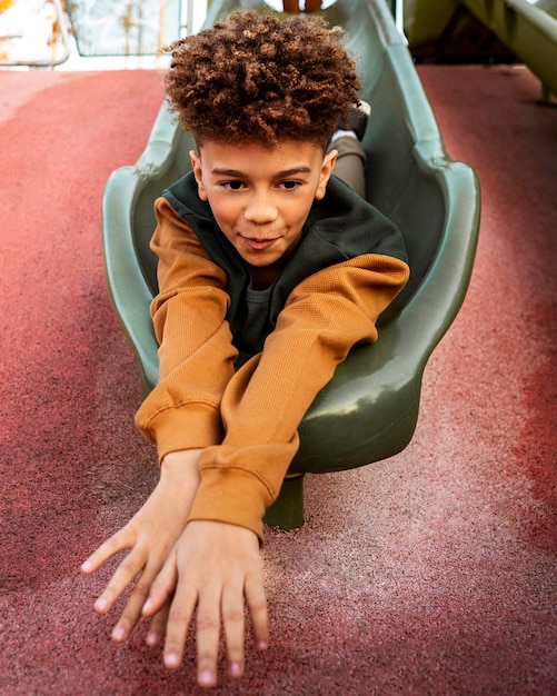 Foto niño jugando en un tobogán