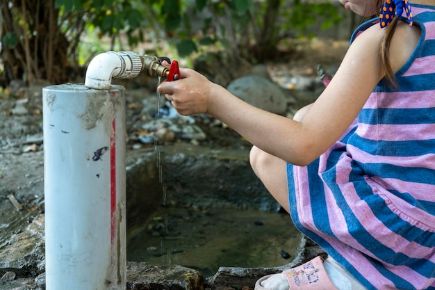 Un niño jugando en una tubería de agua con arena