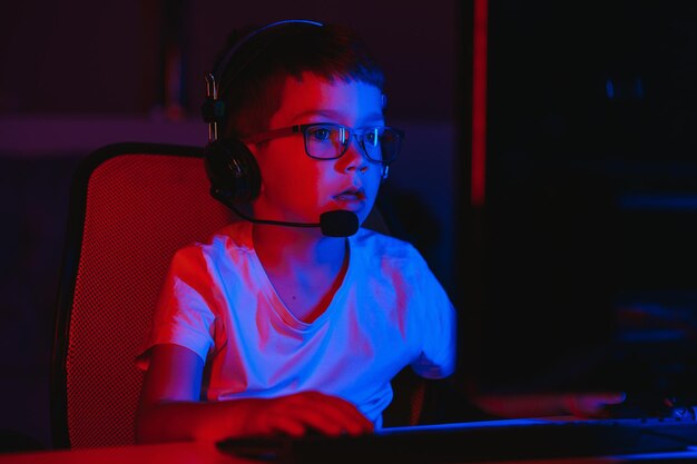 Niño jugando videojuegos en el cuarto oscuro