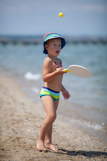 Niño juguetón en la playa. Diversión en vacaciones de verano
