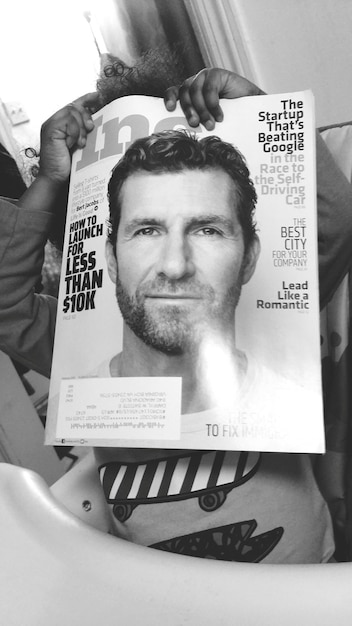 Foto niño juguetón con una revista en la cara.