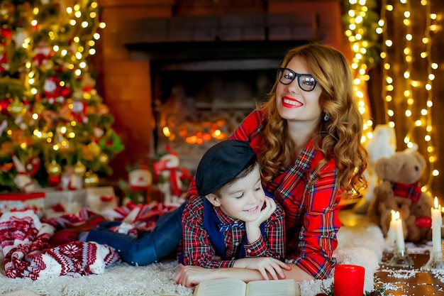 El niño junto con su madre en casa en el contexto de las decoraciones de Año Nuevo.