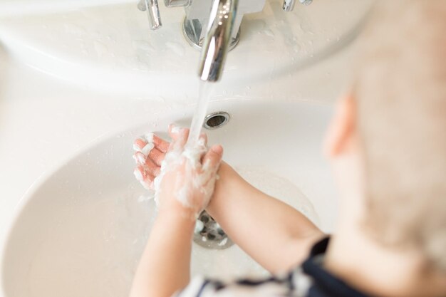 Niño se lava las manos con jabón