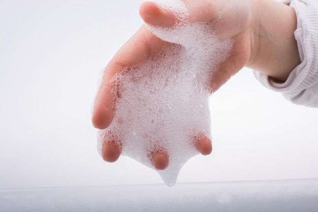 Niño lavándose las manos en espuma