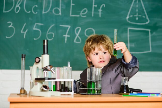 Niño en lección. De vuelta a la escuela. experimentos científicos con microscopio en laboratorio. El niño pequeño está haciendo experimentos. científico del niño de la escuela que estudia la ciencia. ciencia de la biología. Vale la pena explorar la ciencia.