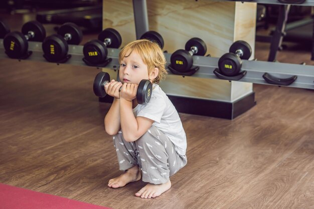 Un niño levanta una pesa en el gimnasio.