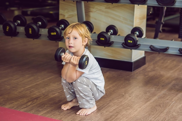 Un niño levanta una pesa en el gimnasio.