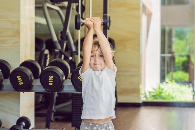 Foto un niño levanta una pesa en el gimnasio.