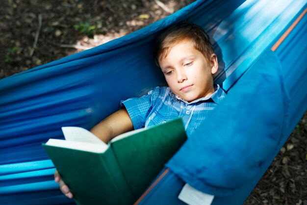 Niño leyendo en la hamaca