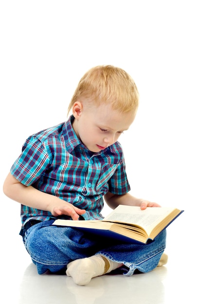 Niño leyendo un libro aislado en un fondo blanco