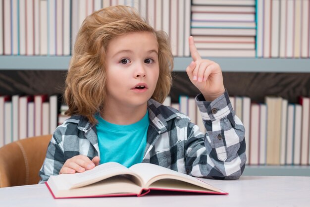 Niño leyendo un libro en una biblioteca escolar Concepto de educación escolar