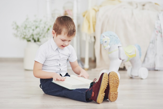 Niño leyendo un libro. Educación, conocimiento, preparándose para la escuela