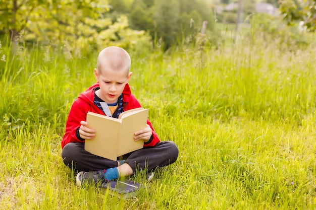 niño leyendo un libro en la hierba