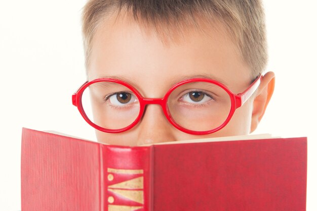 Niño leyendo un libro sediento de conocimiento aislado