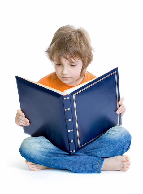 Foto niño leyendo libro sobre fondo blanco.