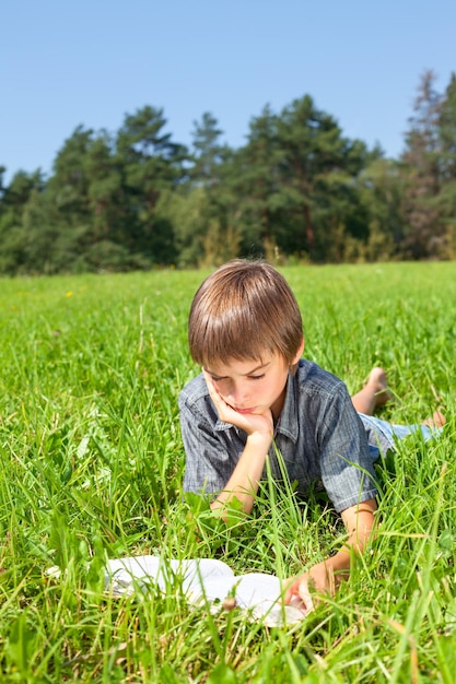 Niño leyendo libros al aire libre