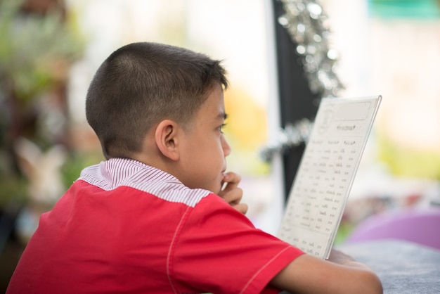 Niño leyendo el menú en el restaurante