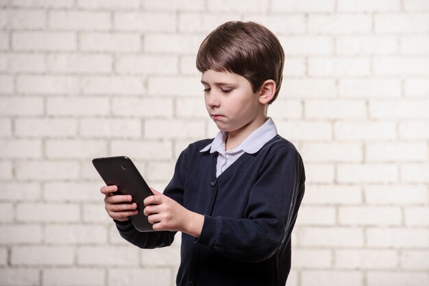 Niño con un libro sobre un fondo blanco.