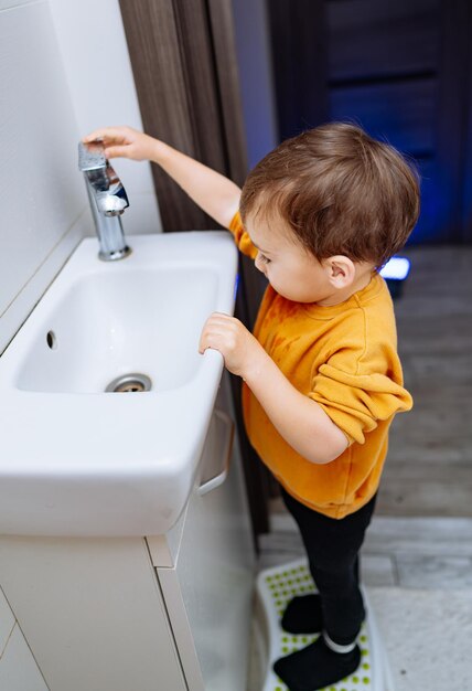 Niño limpiando con manos de jabón Niño aprendiendo a lavarse las manos