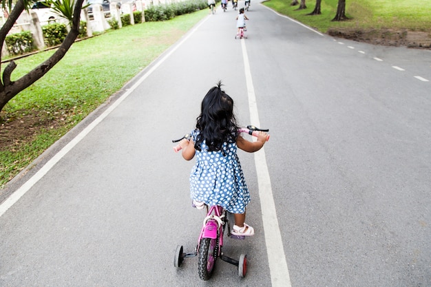 Niño linda niña montando bicicleta en el parque