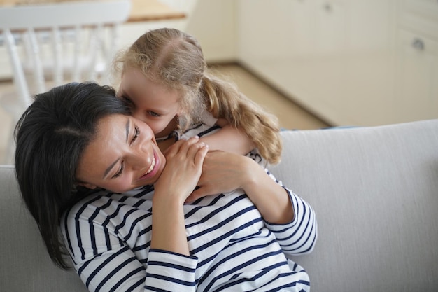 Un niño lindo abraza a una mamá guapa Una familia feliz y afectuosa tiene momentos juntos en casa