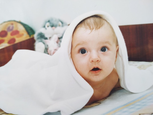Un niño lindo acostado en la cama en casa.