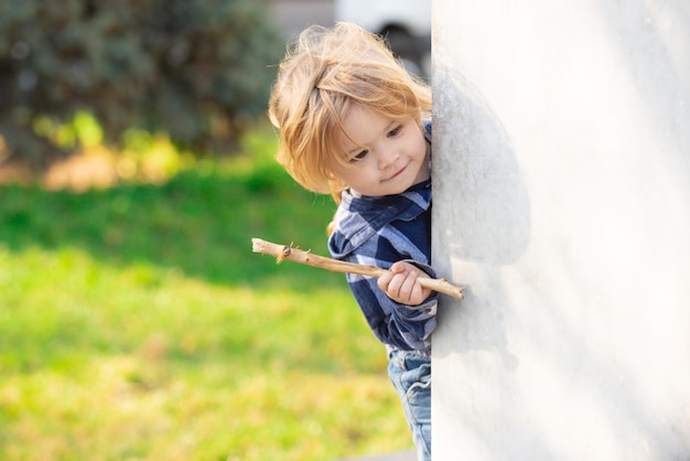 Niño lindo al aire libre jugando al escondite adorable niño divirtiéndose en la infancia del parque