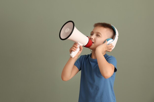 Niño lindo con auriculares y megáfono en color