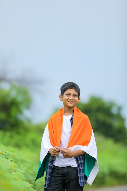 Niño lindo con la bandera tricolor nacional de la India