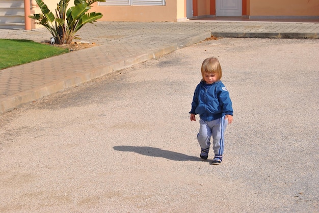 Foto un niño lindo caminando por el sendero.