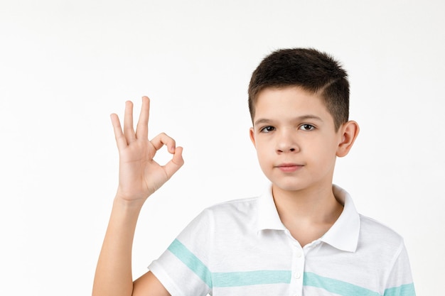 un niño lindo en camiseta haciendo un gesto de Ok