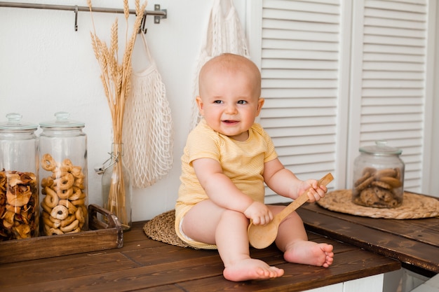 Niño lindo en la cocina de madera de la casa