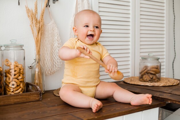 Niño lindo en la cocina de madera de la casa