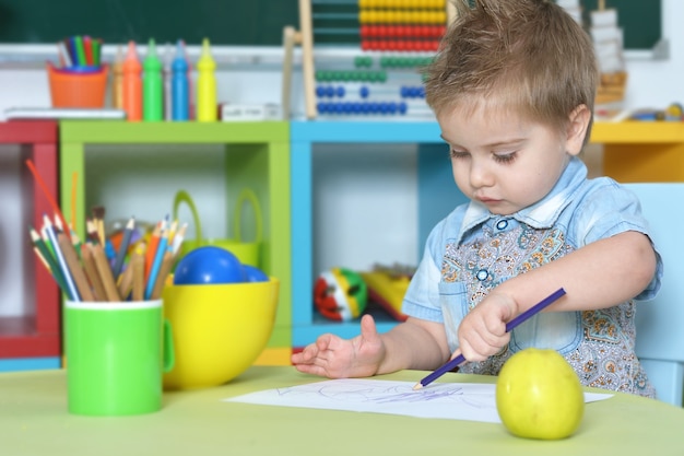 Niño lindo dibujo en casa o jardín de infantes