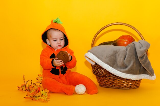 Niño lindo en un disfraz de calabaza de Halloween