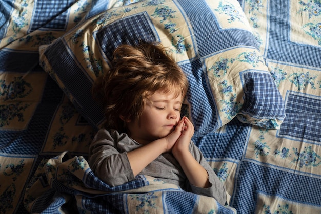 Niño lindo durmiendo en la cama. Los adorables niños pequeños descansan dormidos, disfrutan de un buen sueño saludable y pacífico o de una siesta.