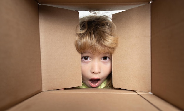 Niño lindo emocionado abriendo un concepto de servicio de entrega de paquetes de cajas de cartón presente