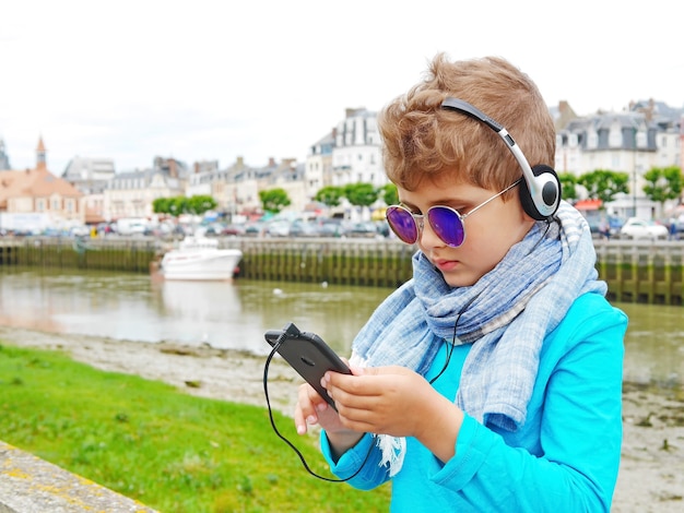 Niño lindo escucha música con auriculares.