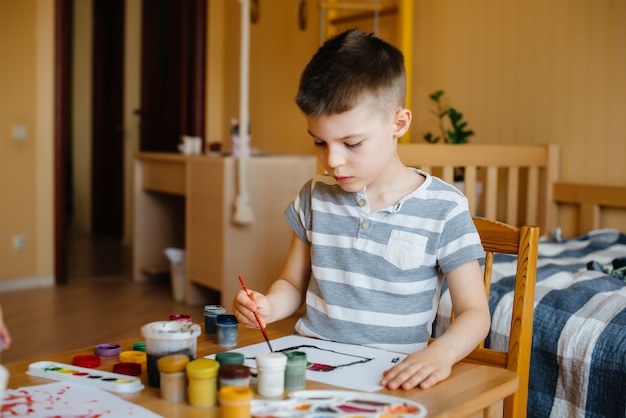 Un niño lindo está jugando y pintando en su habitación. Recreación y entretenimiento. Quédate en casa.