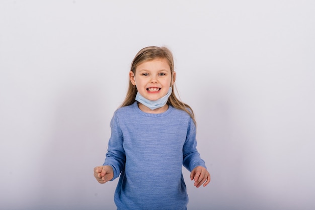 Niño lindo en un estudio, con máscara de protección, concepto de brote de coronavirus.