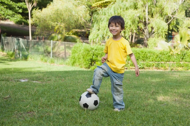 Niño lindo con fútbol en el parque